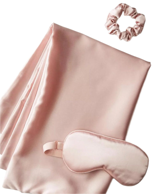 Pink satin eye mask, scarf, and scrunchie on a white background